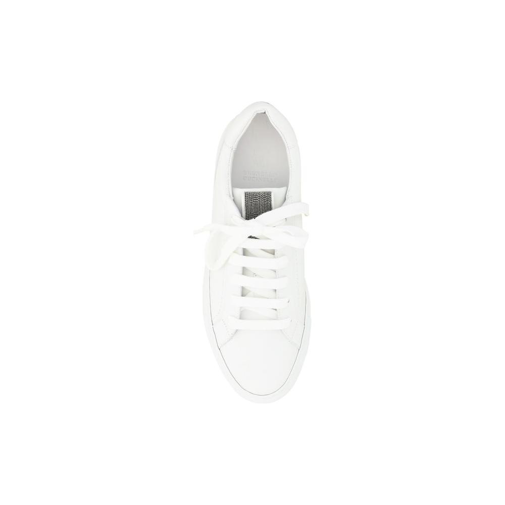 Top view of Brunello Cucinelli white calfskin sneakers with lace-up design and jeweled label.