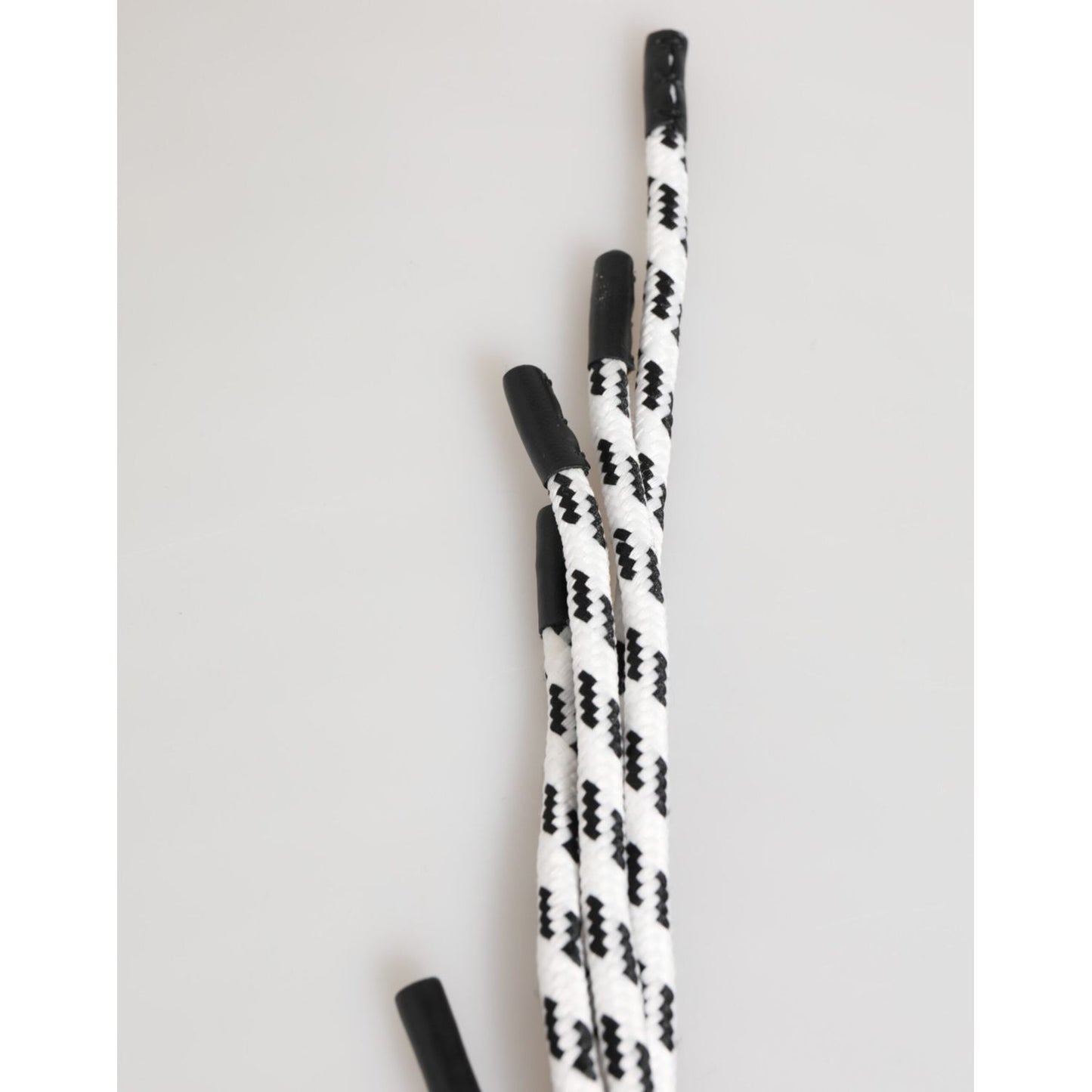 Black and white patterned shoelaces on a light background, close-up view