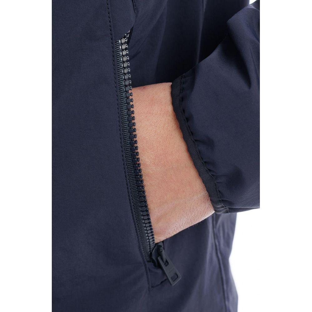 Close-up of a hand in a pocket of a Herno blue nylon jacket with a zip and detachable sleeves.