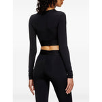 Back view of a woman wearing a black cropped Diesel sweater with long sleeves and a round neck. Focus keyword: Diesel Sweaters Black.