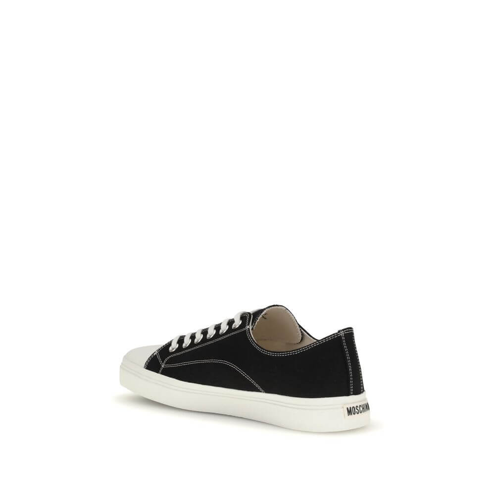 Moschino Black Cotton Low Top Sneakers with lace-up closure, reinforced round toe, flat sole, and logo on heel, side view.