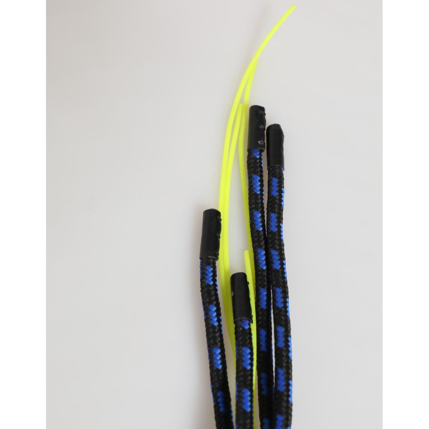 Black and blue braided cords with neon yellow tips against a plain background