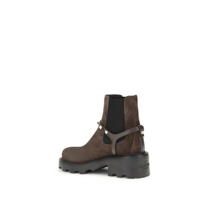 Valentino Garavani Brown Calf Leather Bos Taurus Chelsea Boots with lug sole, rounded toe, and iconic "V" buckle strap design.