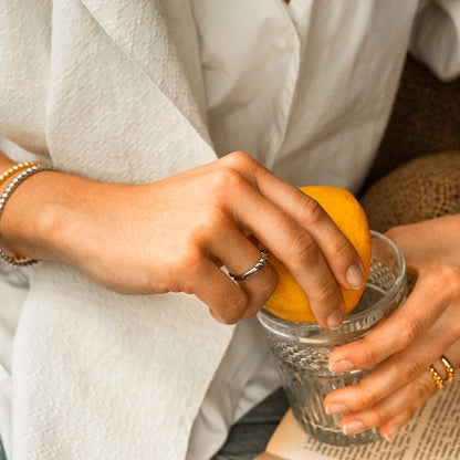 Woman wearing AN JEWELS JEWELRY Mod. AAC.R05S-8 holding a lemon over glass