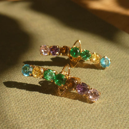 Elegant earrings with colorful gemstones by AN JEWELS JEWELRY Mod. AB.EP035 on display with green fabric background