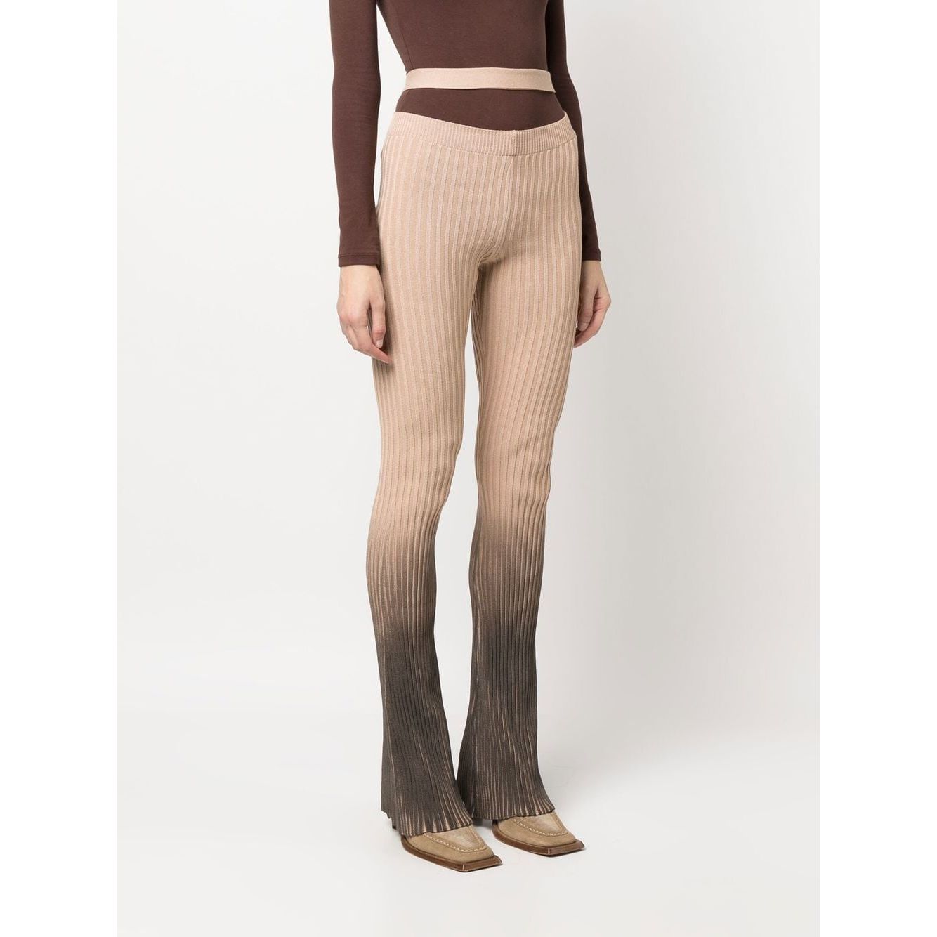 Model wearing ANDREĀDAMO Andrea Adamo Trousers Brown with ribbed flared design, ombré effect, high-waisted cut-out details.