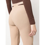 Back view of ANDREĀDAMO Andrea Adamo Trousers Brown with ribbed flared design and cut-out detailing, showcasing ombré stretch fabric.
