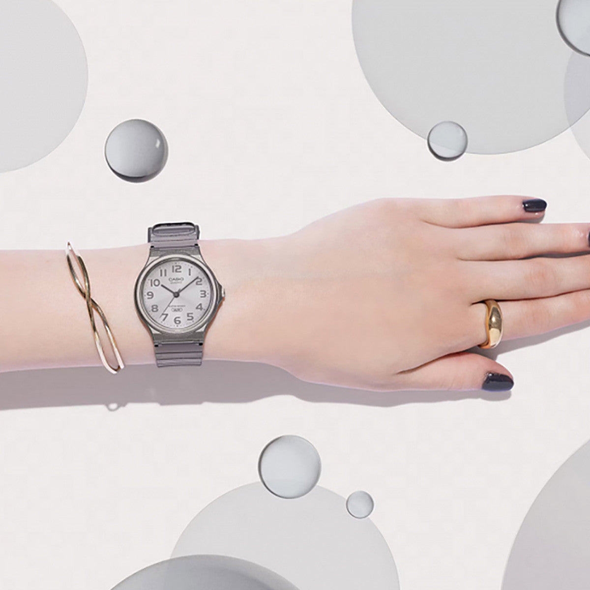 CASIO COLLECTION Mod. POP TRANSLUCID GREY wristwatch on a wrist with gold ring and bracelet, showcasing time-only function, unisex design.