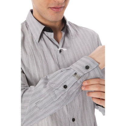 Man adjusting sleeve of a Costume National White Cotton Men Shirt, highlighting the button detailing and elegant Italian collar.