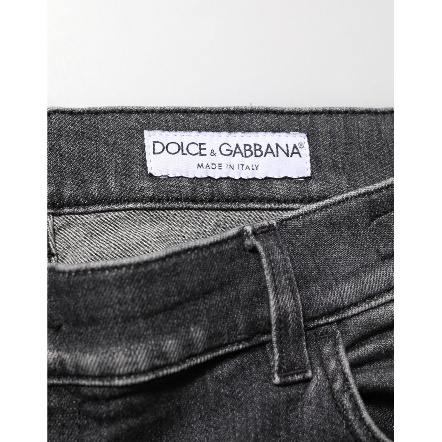 Close-up view of Dolce & Gabbana Black Gray Wash Slim Fit Straight Leg Denim Jeans showcasing brand label and fabric texture.