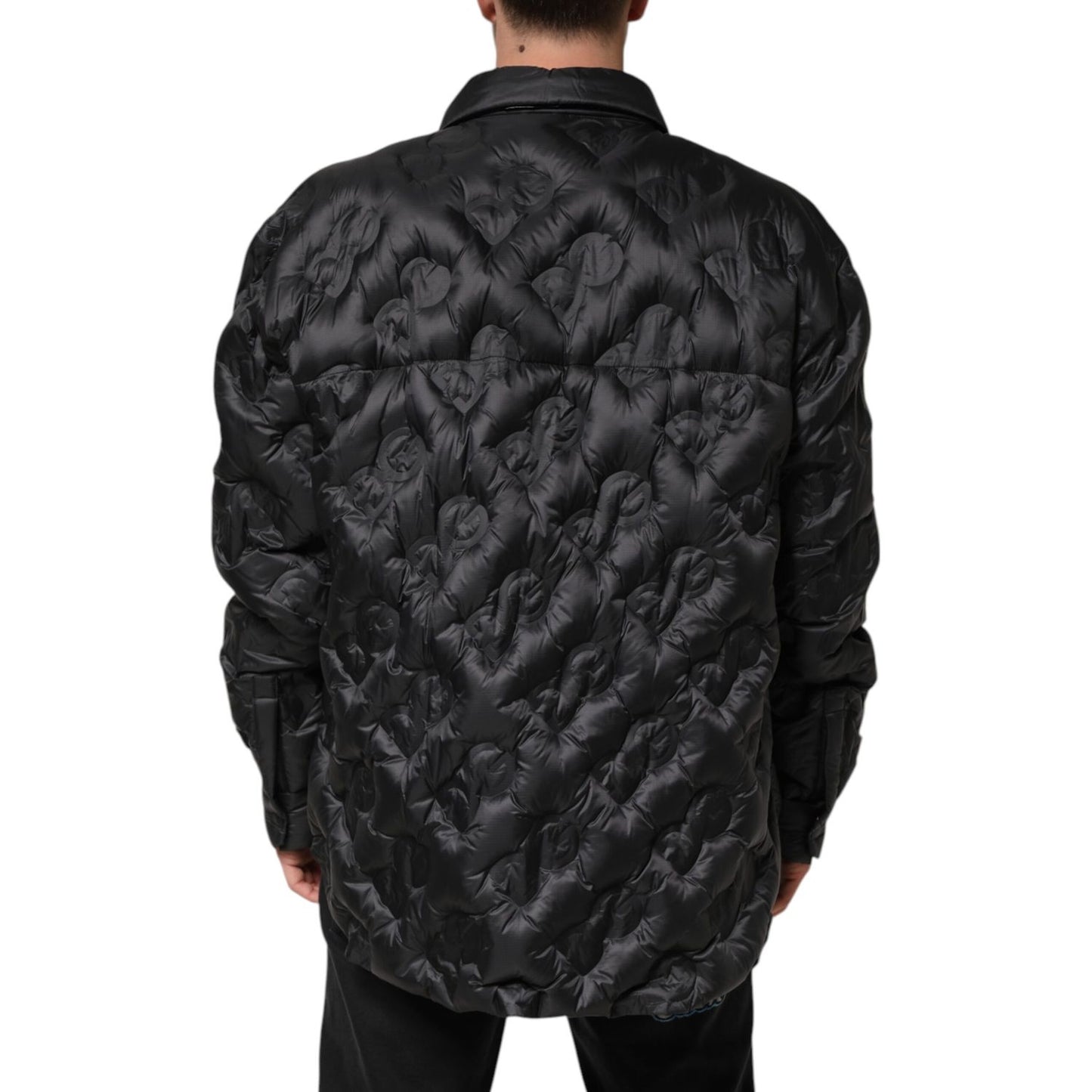 Back view of Dolce & Gabbana Black Quilted DG Logo Nylon Puffer Jacket showcasing rose-inspired embossing and oversized fit.