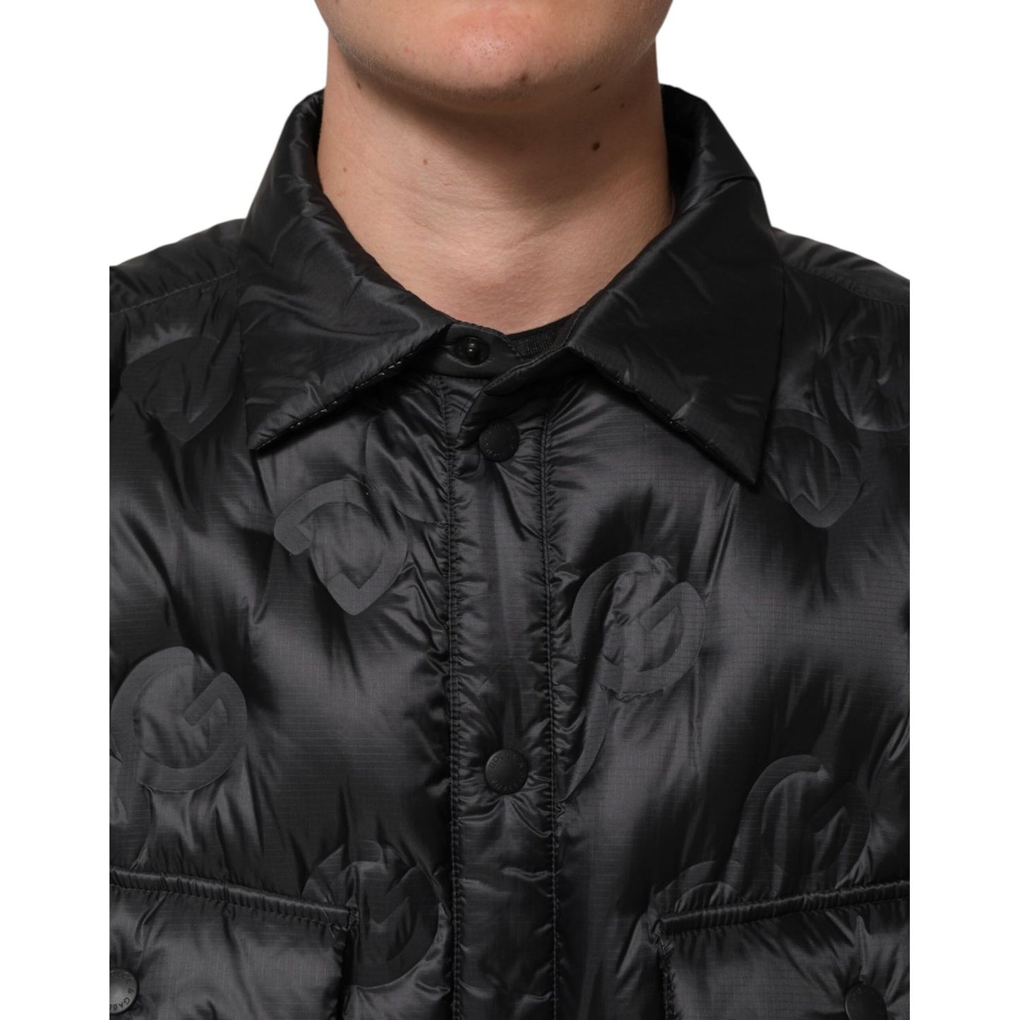 Close-up of Dolce & Gabbana Black Quilted DG Logo Nylon Puffer Jacket with rose-embossed pattern and snap button closure.