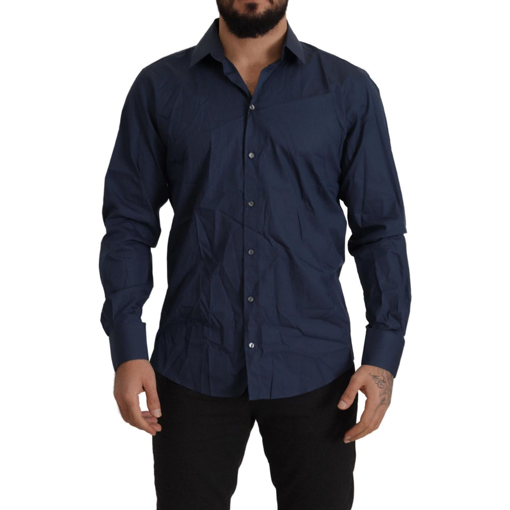 Man wearing Dolce & Gabbana Blue Cotton MARTINI Slim Fit Dress Shirt with button closure and logo details.