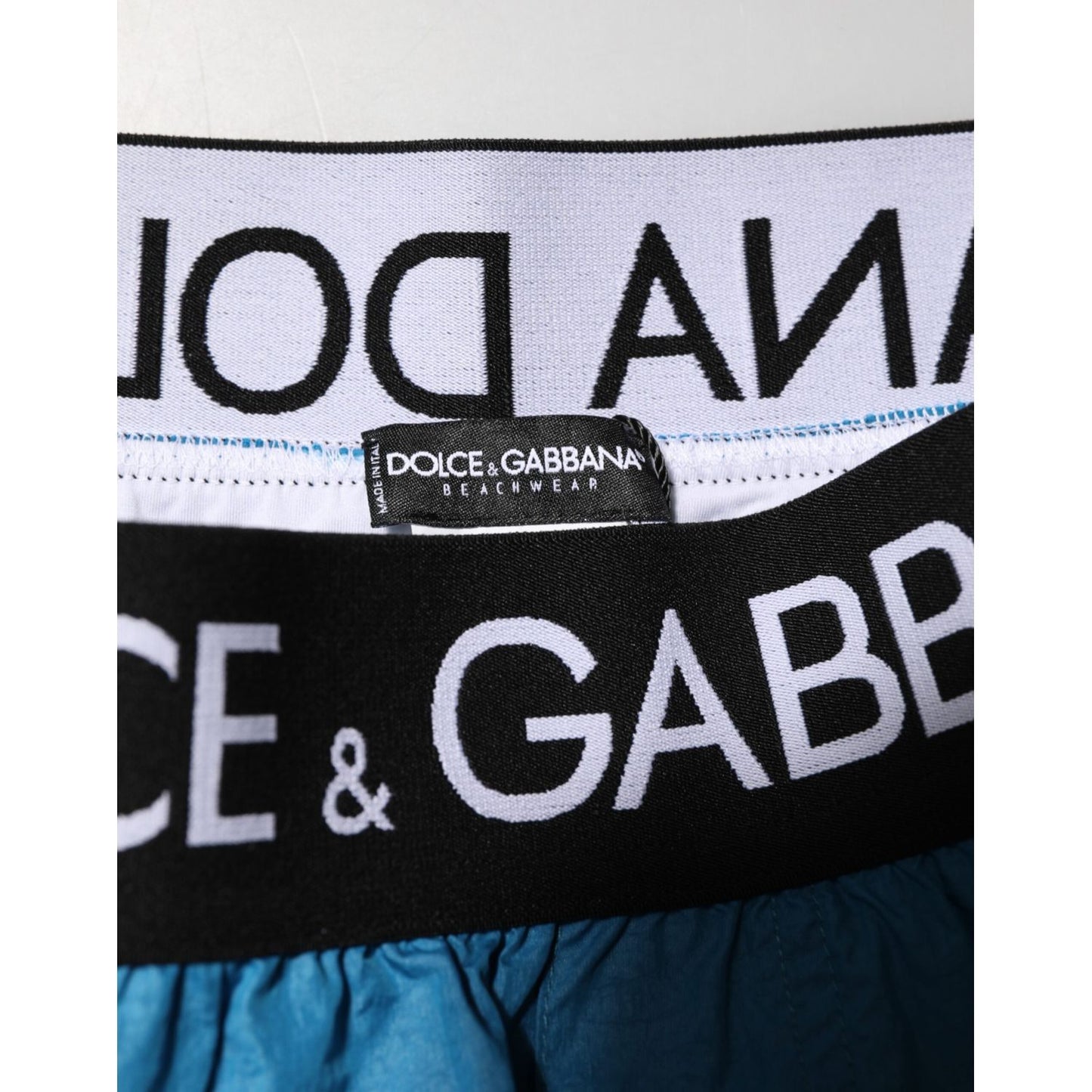 Close-up of Dolce & Gabbana Blue Logo Waistband Beachwear Shorts Swimwear showcasing the brand's iconic logo on the waistband.