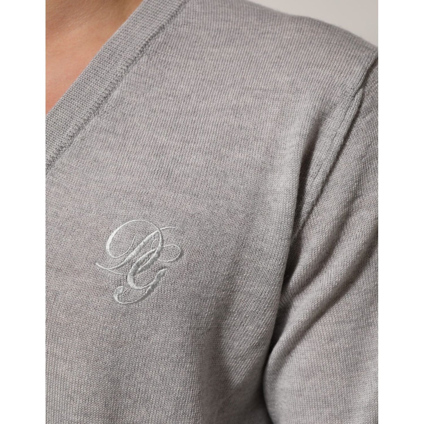 Close-up of Dolce & Gabbana Gray Wool Knit Logo V-Neck Pullover Sweater, showcasing the embroidered logo detail on soft gray wool.