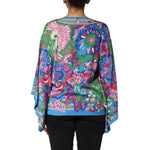 Back view of Dolce & Gabbana Multicolor Floral Print Silk Tunic Blouse Top with vibrant floral design, styled on model.