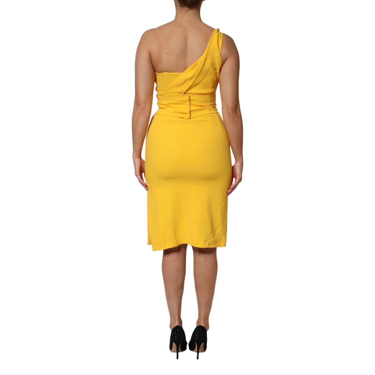 Back view of a model wearing a Dolce & Gabbana Yellow One Shoulder Side Slit Sheath Dress in a sheath silhouette.
