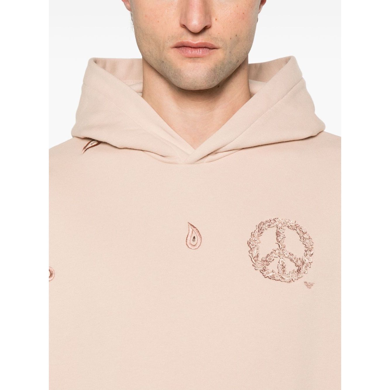 Model wearing Emporio Armani Sweaters Powder in blush pink with hood, drop shoulder, and logo print.