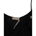 Close-up of label on John Galliano Black cocktail dress with spaghetti straps and logo details. Elegant above knee length dress.