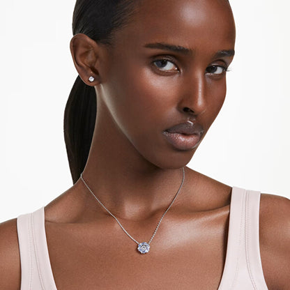 Woman wearing SWAROVSKI Mod. 5685437 earrings and necklace, showcasing silver jewelry with elegant design and quartz analog movement.