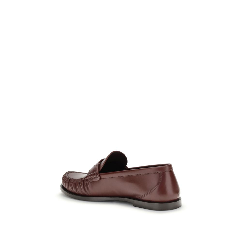 Saint Laurent Brown Calf Leather Bos Taurus Slip-On Loafers showing side and back view with gold metal Cassandre decoration.