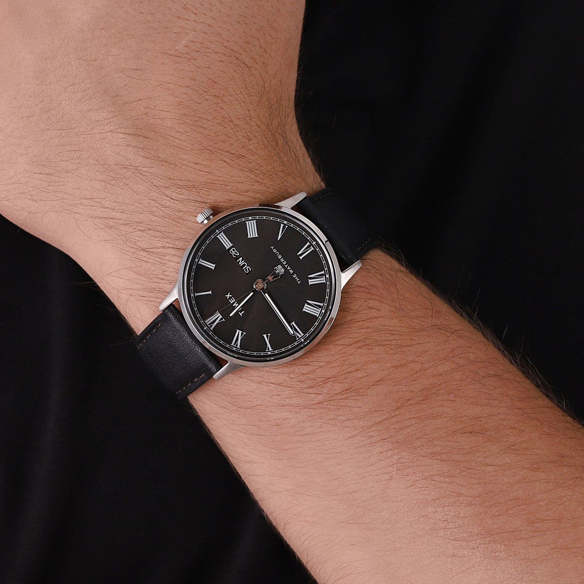 TIMEX Mod. WATERBURY CLASSIC wristwatch on wrist, stainless steel case, black leather strap, mineral dial, quartz movement, 5 ATM water resistant.