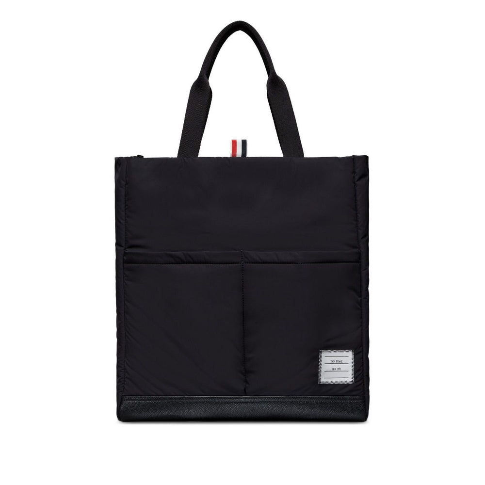 Thom Browne Multi pocket tote bag in black with two top handles, front patch pockets, and internal zip pocket, comes with dust bag.