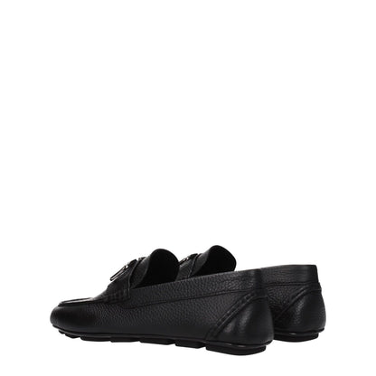 Valentino Garavani Black Leather Slip-On Loafers with silver front logo and rubber sole, low heel, stylish round toe design.