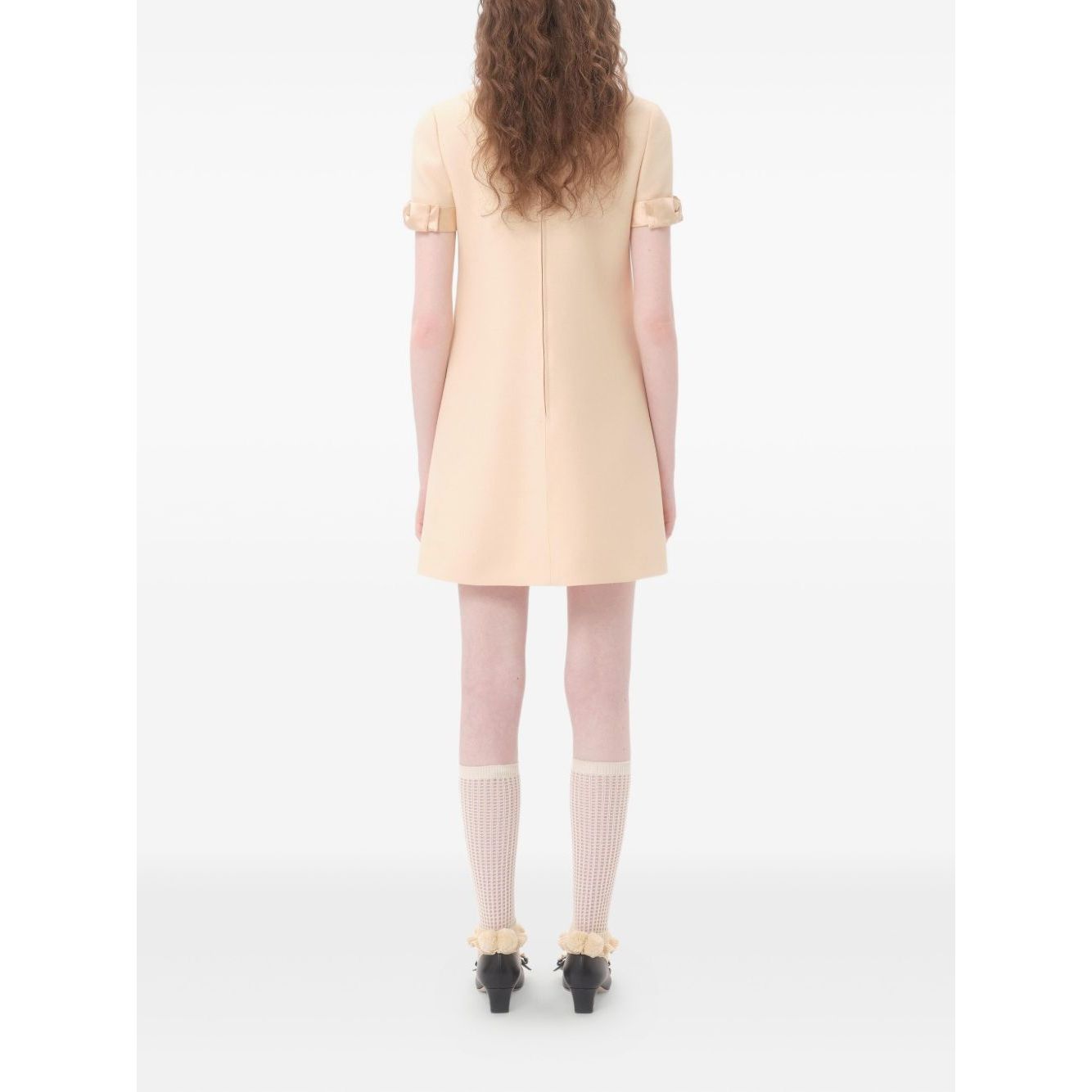 Back view of Valentino Short Crepe Couture Dress in beige with bow detailing, rear zip fastening, crew neck, wool and silk blend.