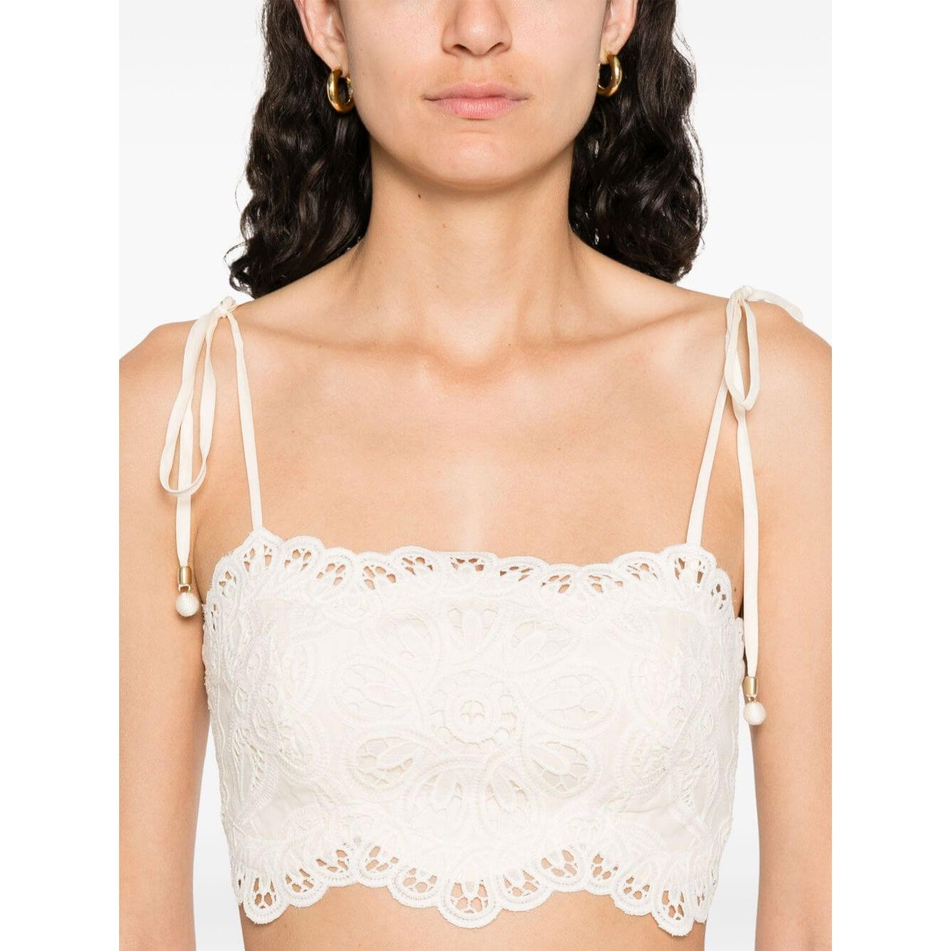 Zimmermann Cropped top with beige tie-fastening straps, floral cut-out detailing, and embroidered bodice featuring lettuce hem design.